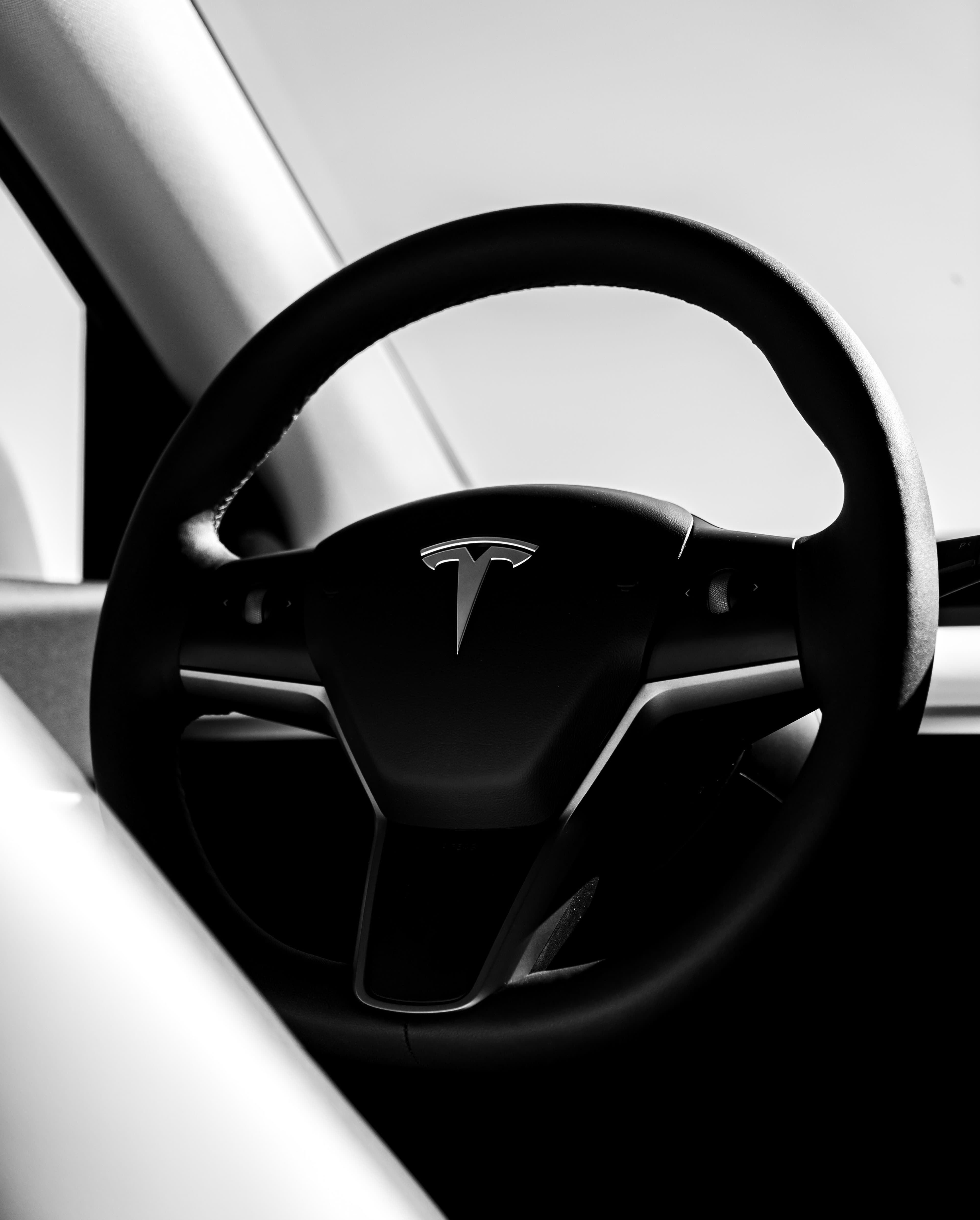 Tesla Model Y interior with steering wheel featuring Tesla logo